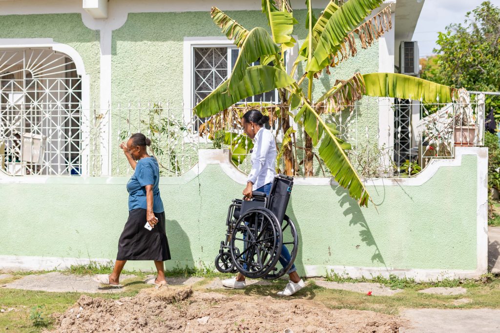 Terri-Karelle walks through a Greater Portmore community to deliver a wheelchair as part of the ODJF accessibility initiative